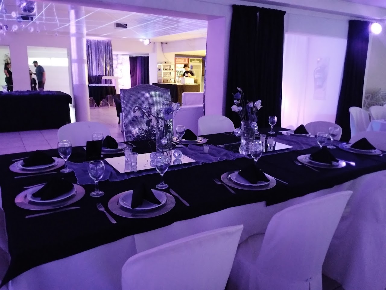 Mesa elegante ambientada con mantelería negra y centros de mesa en Metrópolis Espacio de Eventos